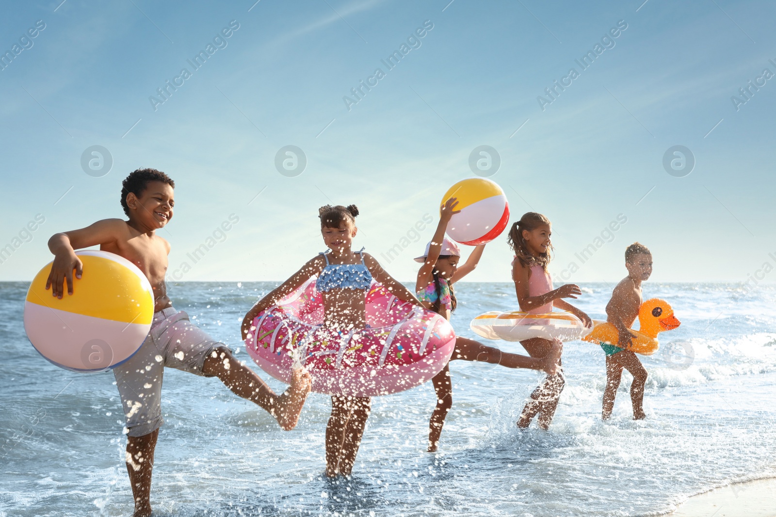 Photo of Cute children enjoying sunny day at beach. Summer camp