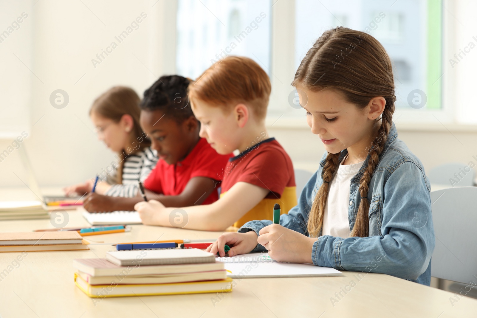 Photo of Cute children studying in classroom at school