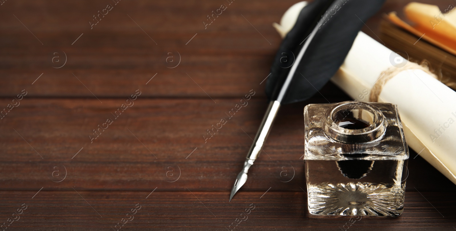 Image of Quill, inkwell and paper roll on wooden table, space for text. Banner design