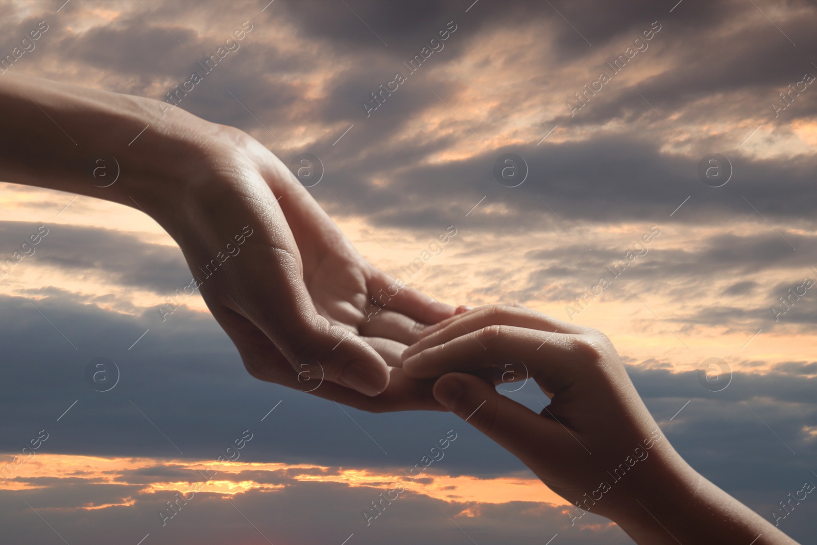 Image of Godparent with child and beautiful sky with clouds at sunset on background, closeup