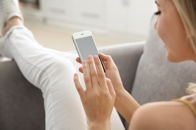 Young woman using phone indoors