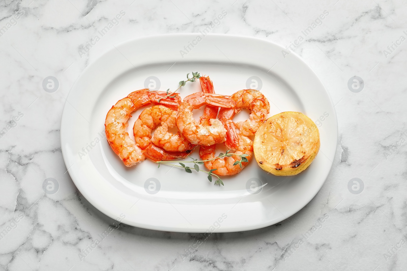 Photo of Plate with delicious fried shrimps and lemon on light background, top view