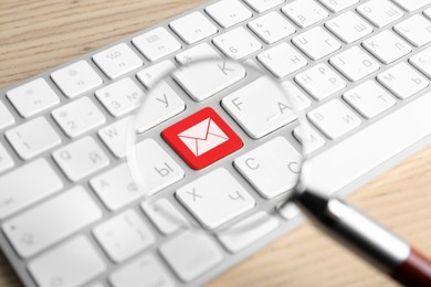 Image of Email. Red button with illustration of envelope on computer keyboard, view through magnifying glass, closeup