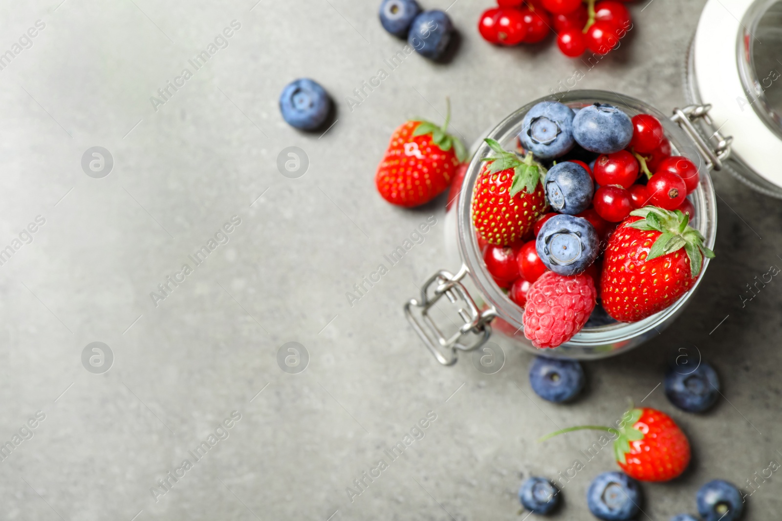 Photo of Mix of ripe berries on grey table, flat lay. Space for text