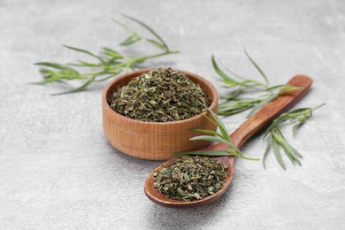 Photo of Dry and fresh tarragon on light gray textured table