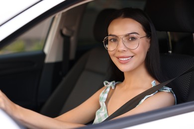Photo of Enjoying trip. Happy young woman in car, view from outside