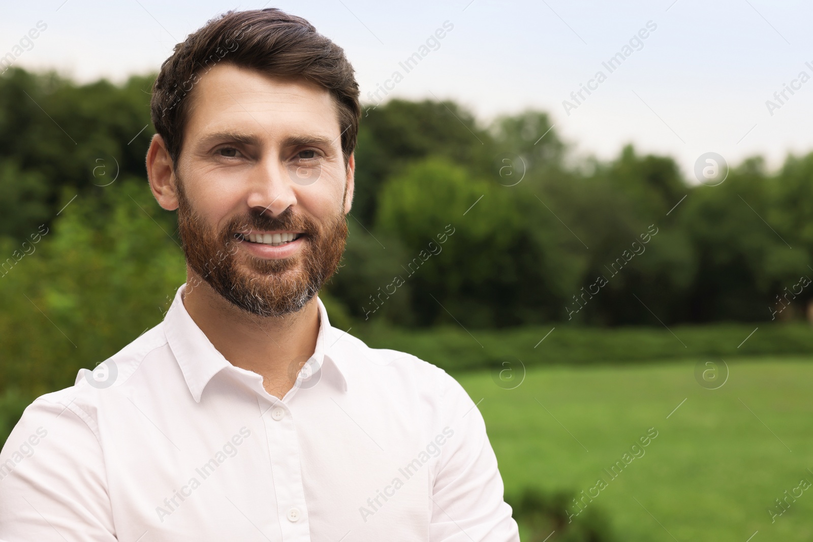 Photo of Portrait of handsome bearded man in park, space for text