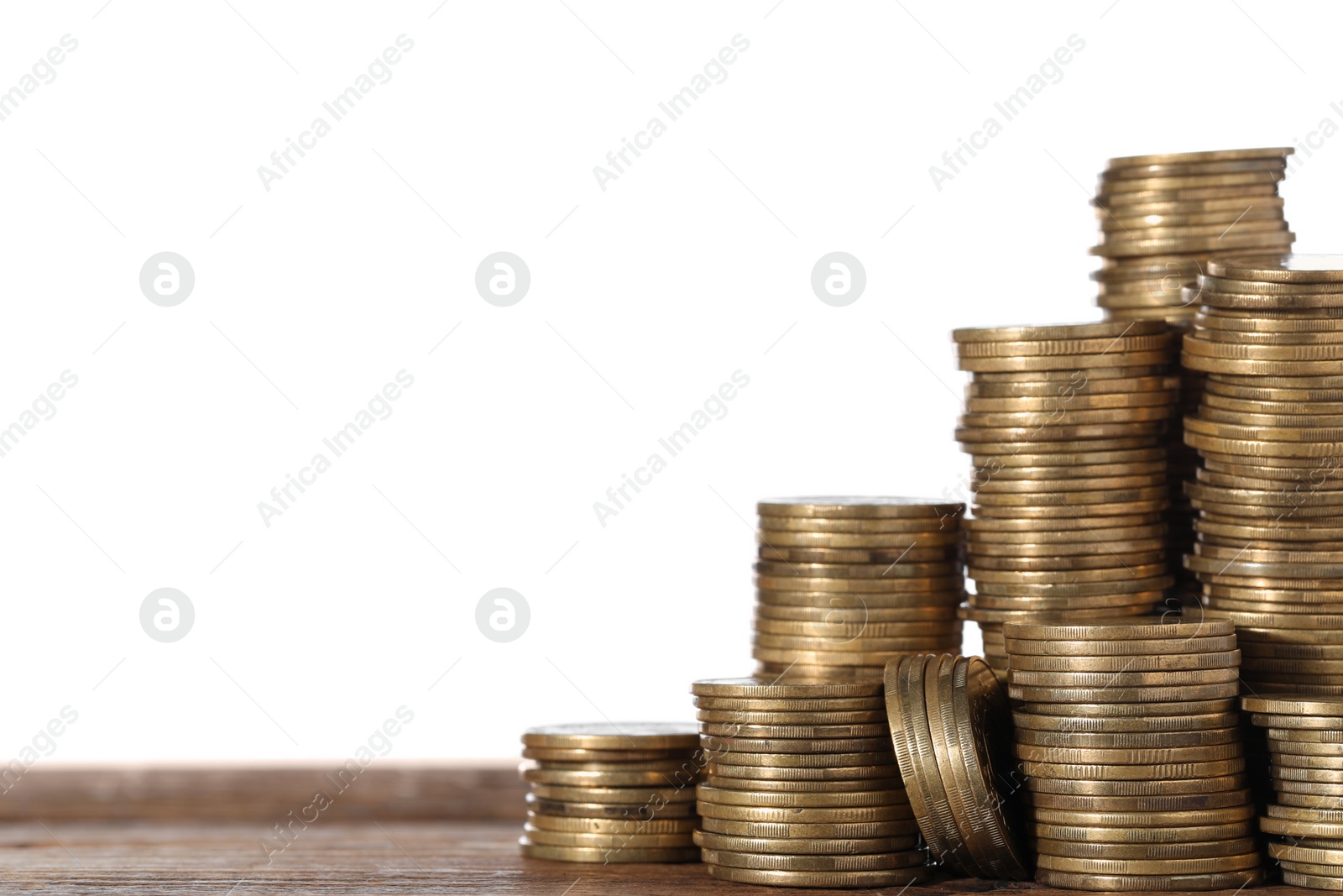 Photo of Stack of coins on wooden table, closeup. Space for text