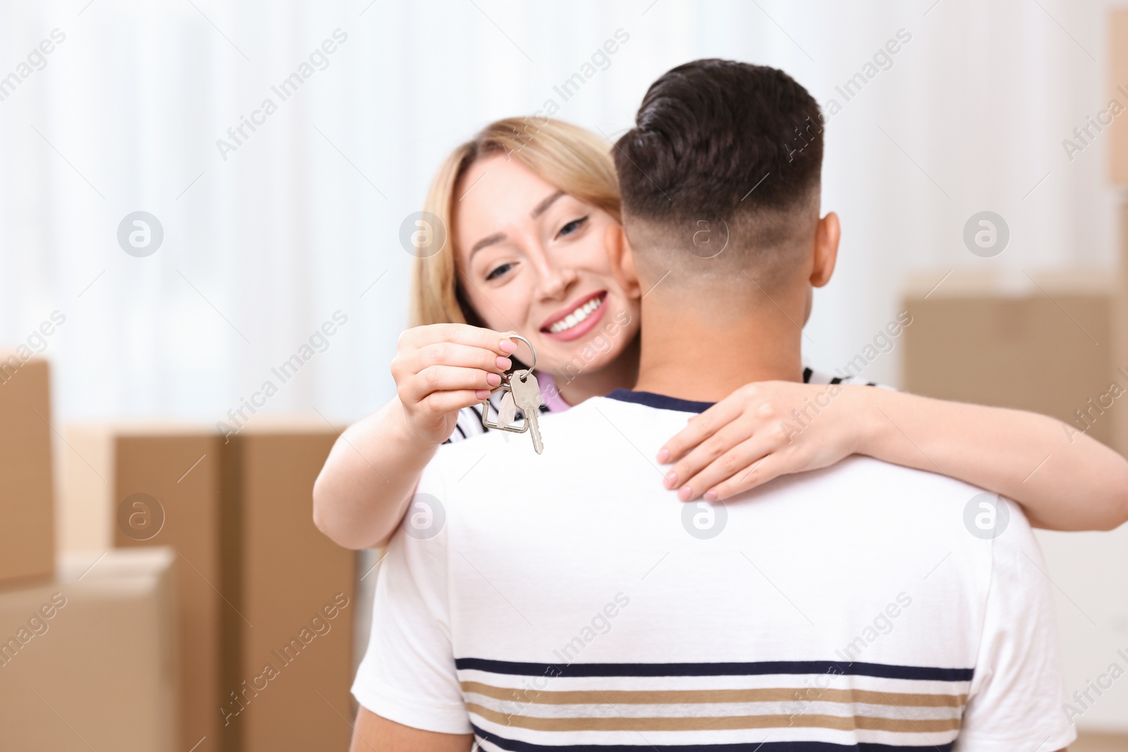 Photo of Happy couple with key from their new house indoors