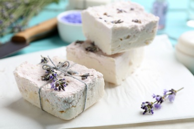 Photo of Hand made soap bars with lavender flowers on white paper, closeup