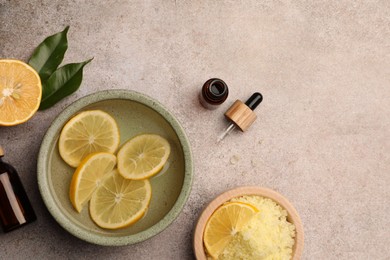 Flat lay composition with essential oil and lemons on grey textured table, space for text. Aromatherapy treatment