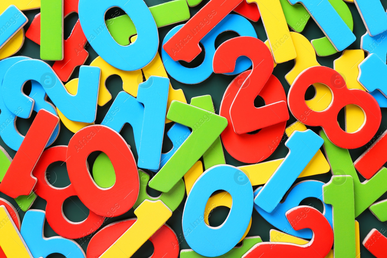 Photo of Colorful numbers on green background, top view