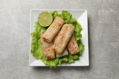 Photo of Delicious fried spring rolls on grey table, top view