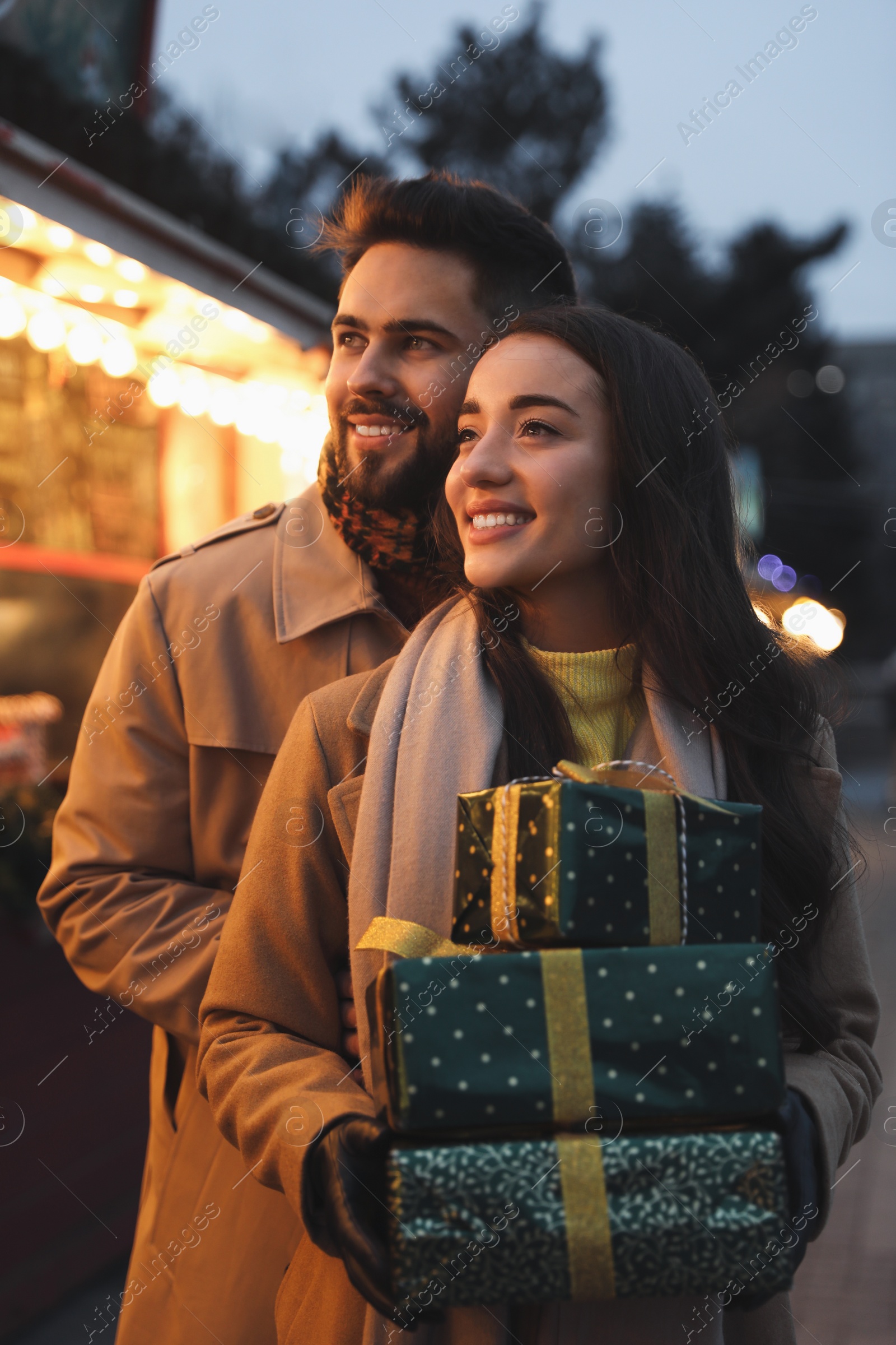 Photo of Lovely couple with Christmas presents at winter fair