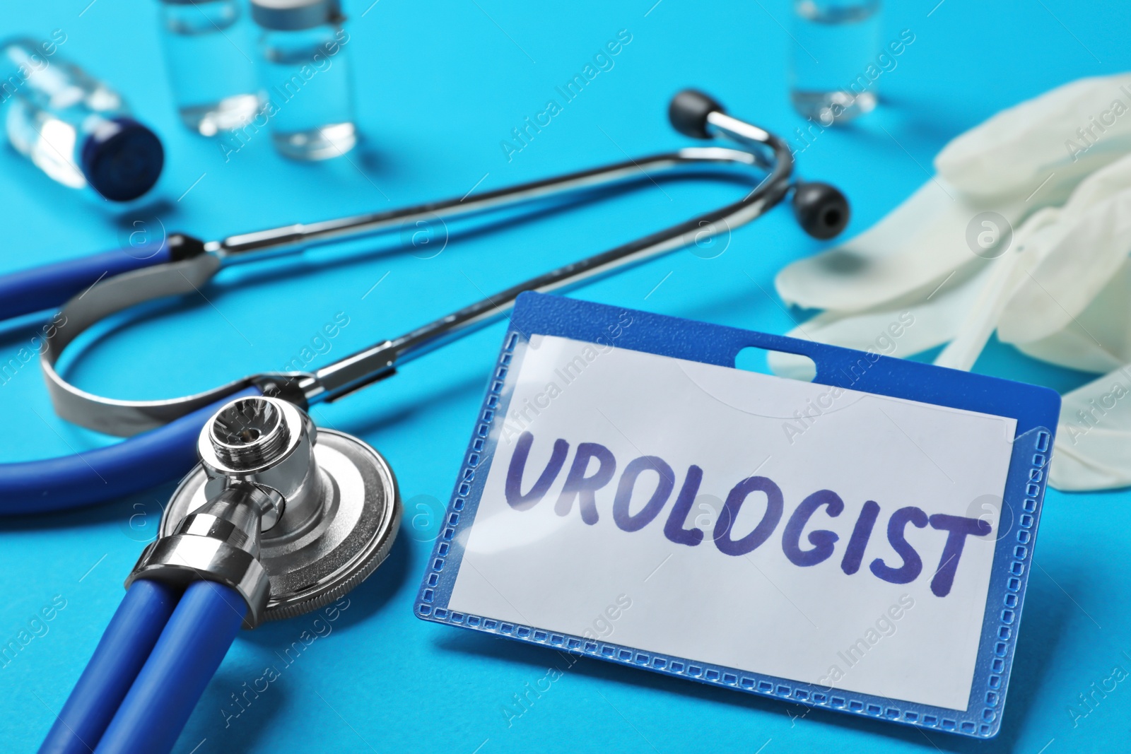 Photo of Badge with inscription UROLOGIST and stethoscope on table