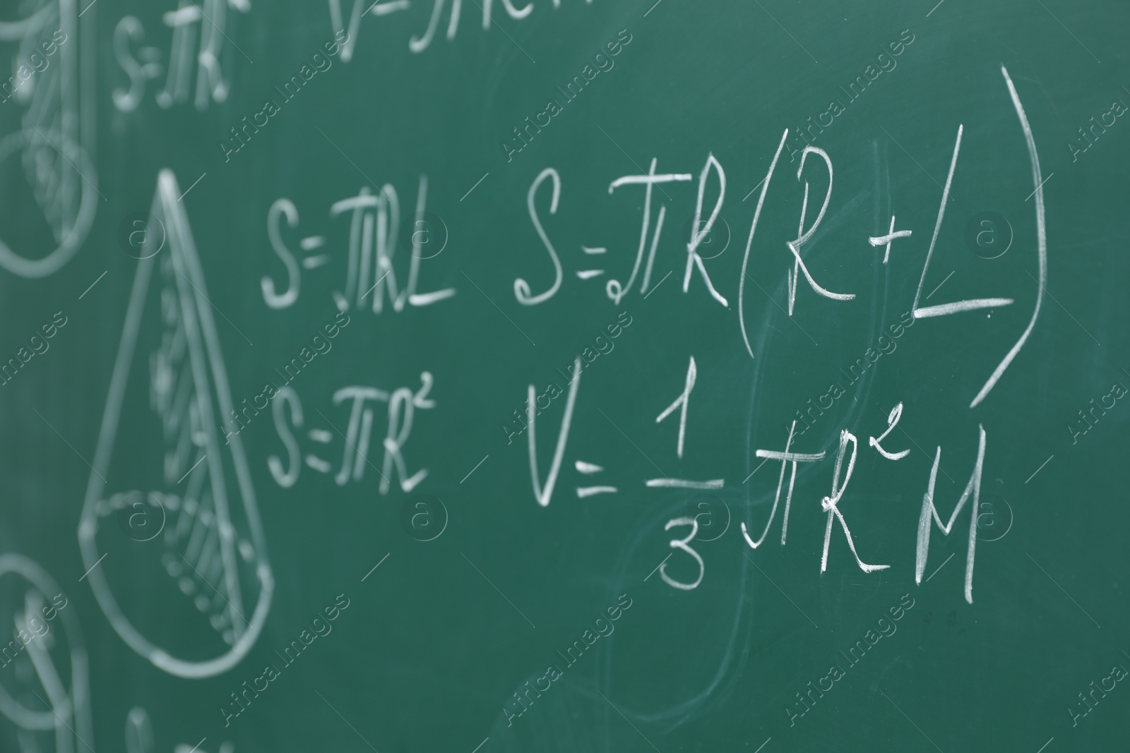 Photo of Different math formulas written with chalk on green board