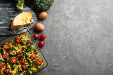 Photo of Flat lay composition with tasty broccoli casserole on grey table. Space for text