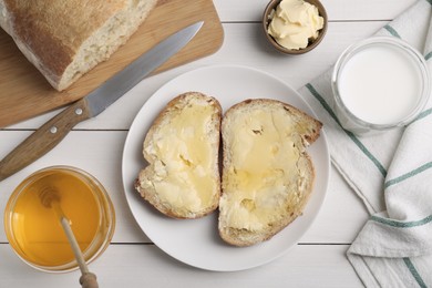 Photo of Flat lay composition of sandwiches with butter, honey and milk on white wooden table