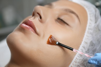 Young woman during face peeling procedure in salon, closeup