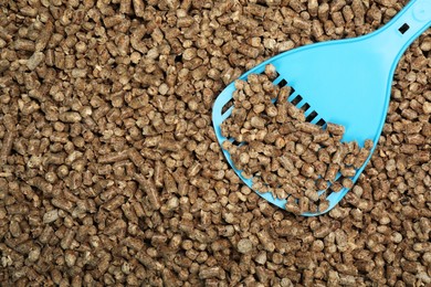 Photo of Wood pellet cat litter with plastic scoop, top view