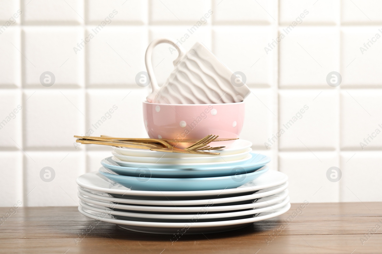 Photo of Beautiful ceramic dishware, cup and cutlery on wooden table