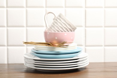 Photo of Beautiful ceramic dishware, cup and cutlery on wooden table