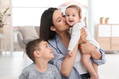 Photo of Happy mother with her cute children at home. Family time