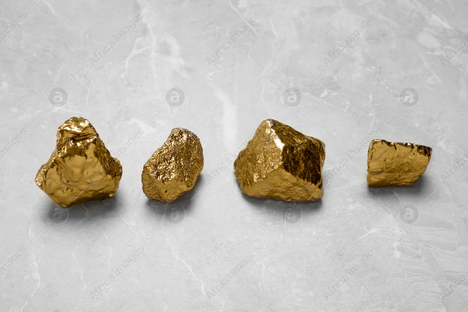 Photo of Gold nuggets on light grey marble table