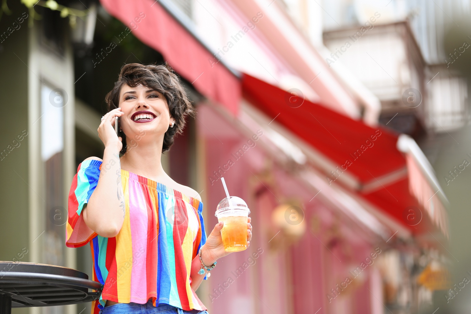 Photo of Young woman with cup of tasty lemonade outdoors