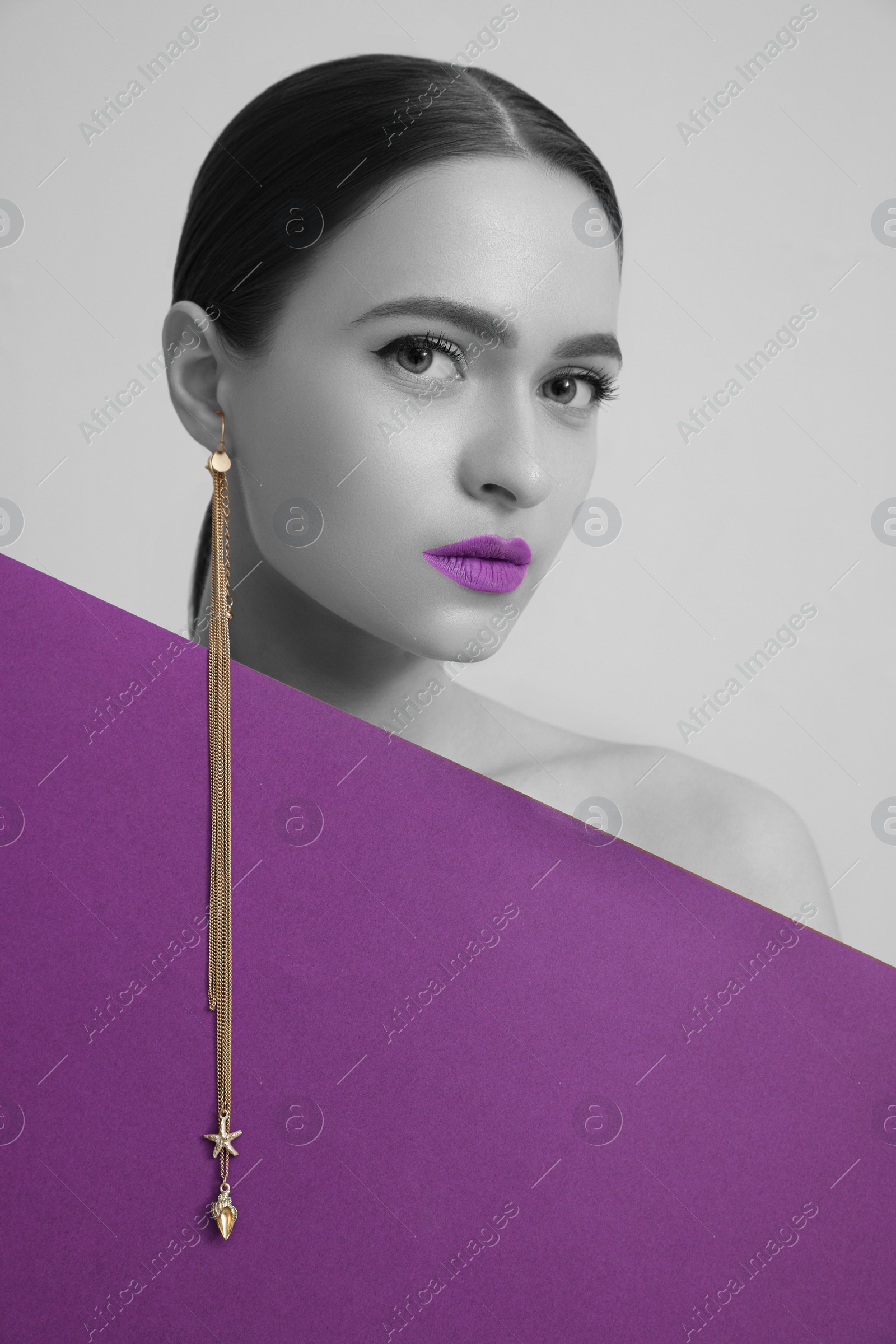 Image of Attractive woman with stylish earring posing on grey background. Color accent