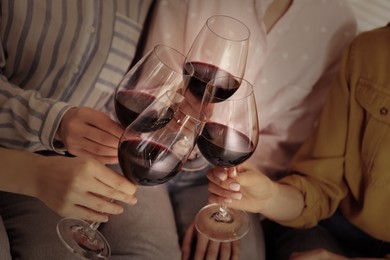 Image of Young women clinking glasses of wine, closeup