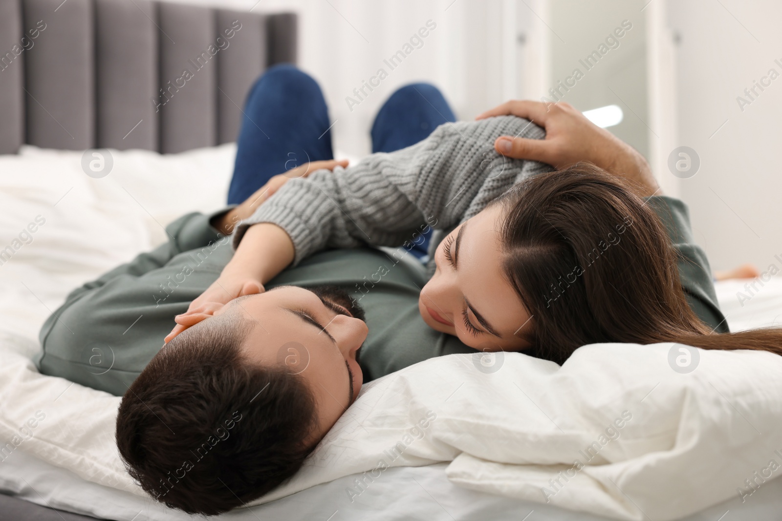 Photo of Affectionate young couple spending time together on bed