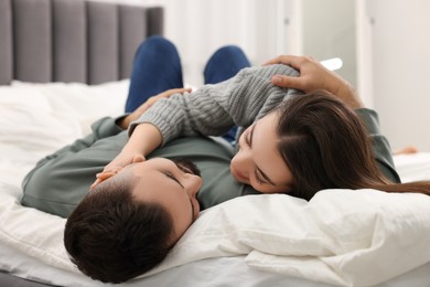 Affectionate young couple spending time together on bed