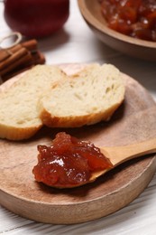 Photo of Delicious apple jam and bread slices on white wooden table, closeup. Space for text
