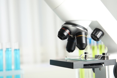 Modern microscope with different lenses in laboratory, space for text. Medical equipment