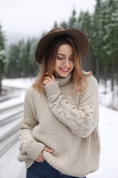 Photo of Young woman in warm sweater outdoors on snowy day. Winter vacation