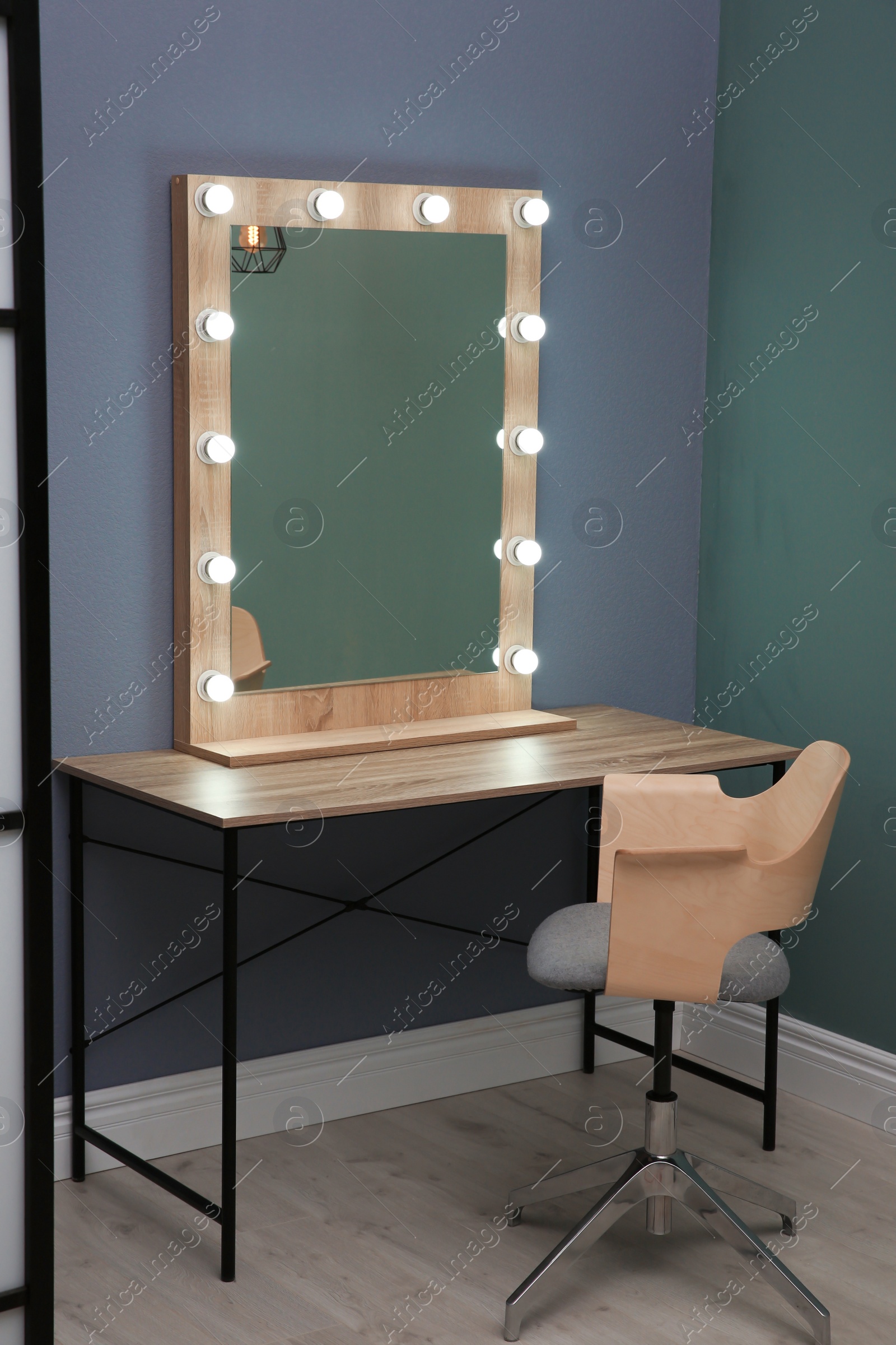 Photo of Beautiful mirror with lamps in modern makeup room