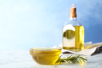 Composition with bowl of rosemary oil on table