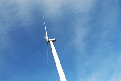 Modern wind turbine against blue sky, low angle view. Alternative energy source