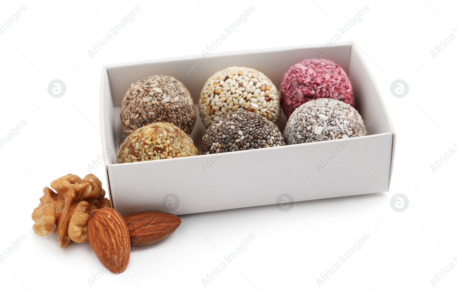 Photo of Different delicious vegan candy balls in box and nuts on white background