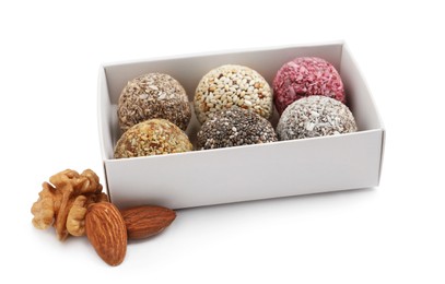 Photo of Different delicious vegan candy balls in box and nuts on white background