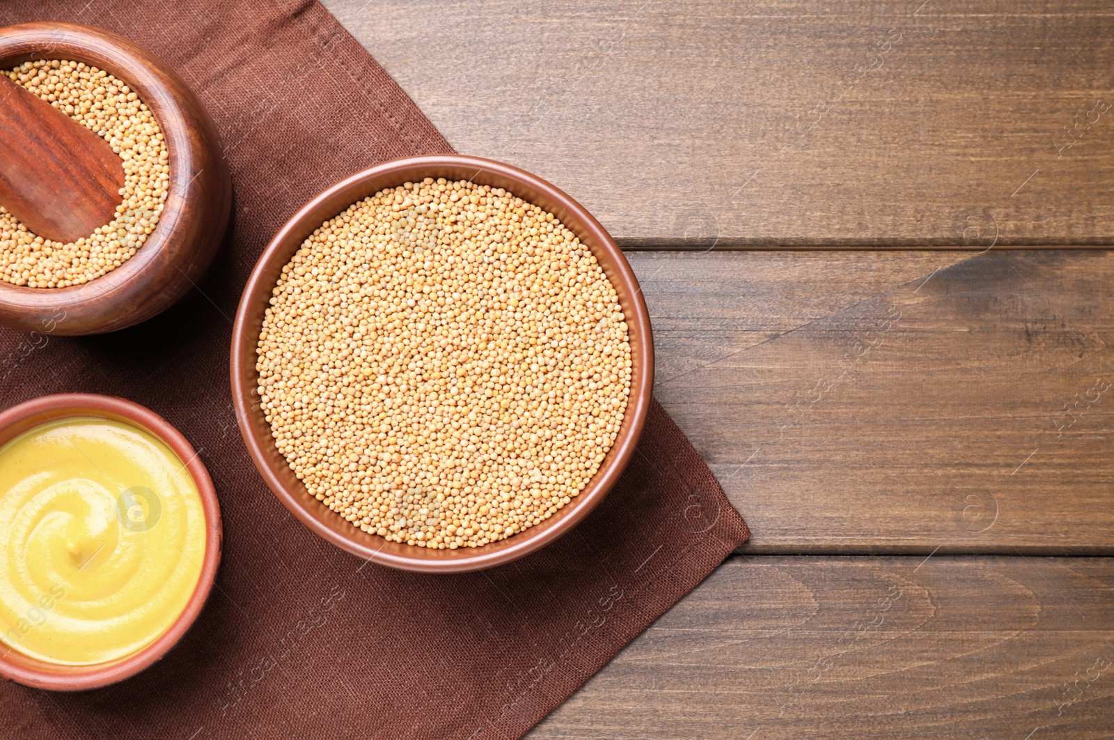 Photo of Flat lay composition with mustard seeds on wooden table, space for text