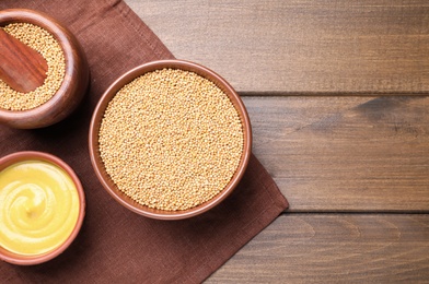 Photo of Flat lay composition with mustard seeds on wooden table, space for text