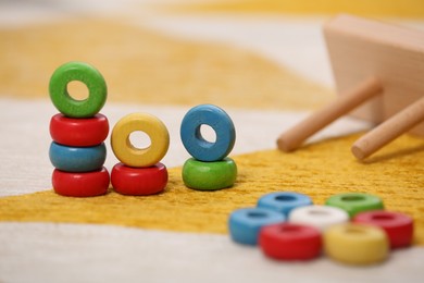 Photo of Stacking and counting game on floor indoors, closeup. Educational toy for motor skills development