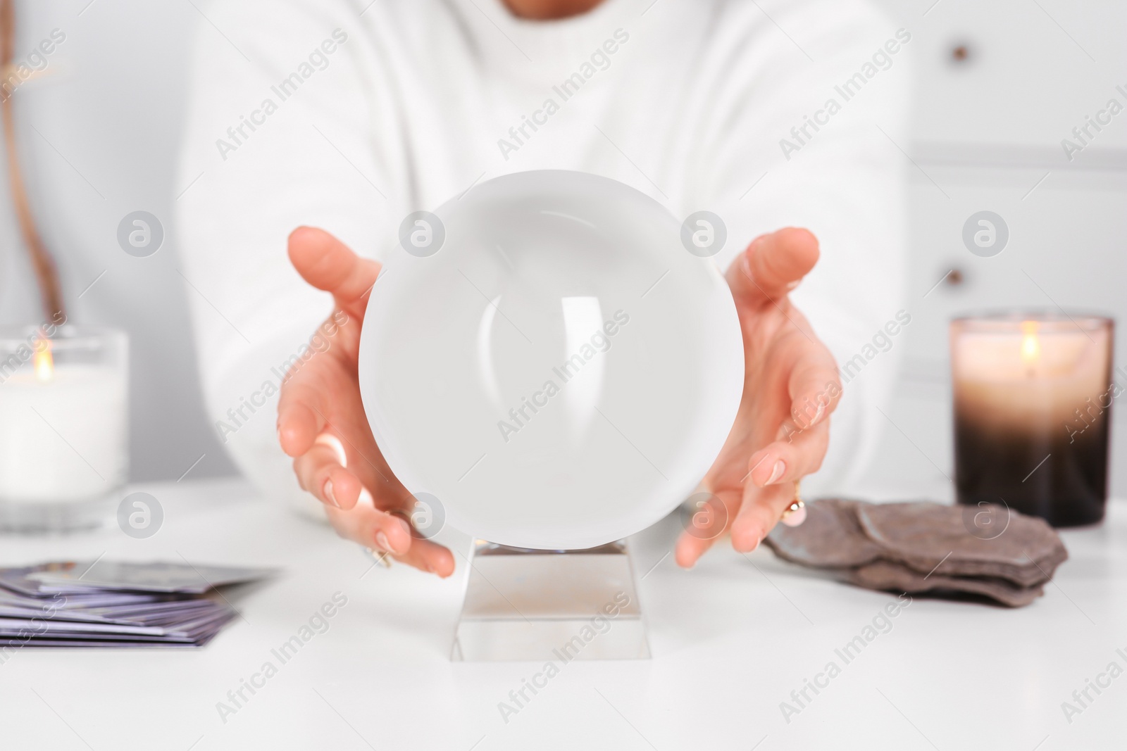 Photo of Soothsayer using crystal ball to predict future at table indoors, closeup