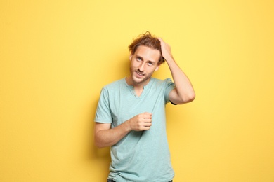 Photo of Young man in casual clothes posing on color background