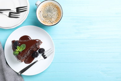 Photo of Delicious chocolate cake with blackberries on light blue wooden table, flat lay. Space for text