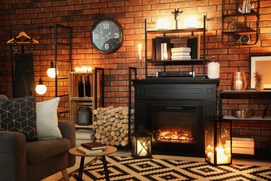 Photo of Stylish living room with beautiful fireplace, armchair and different decor at night. Interior design