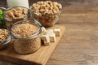 Different organic soy products on wooden table, space for text