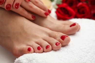Photo of Woman with stylish red toenails after pedicure procedure on white floor, closeup